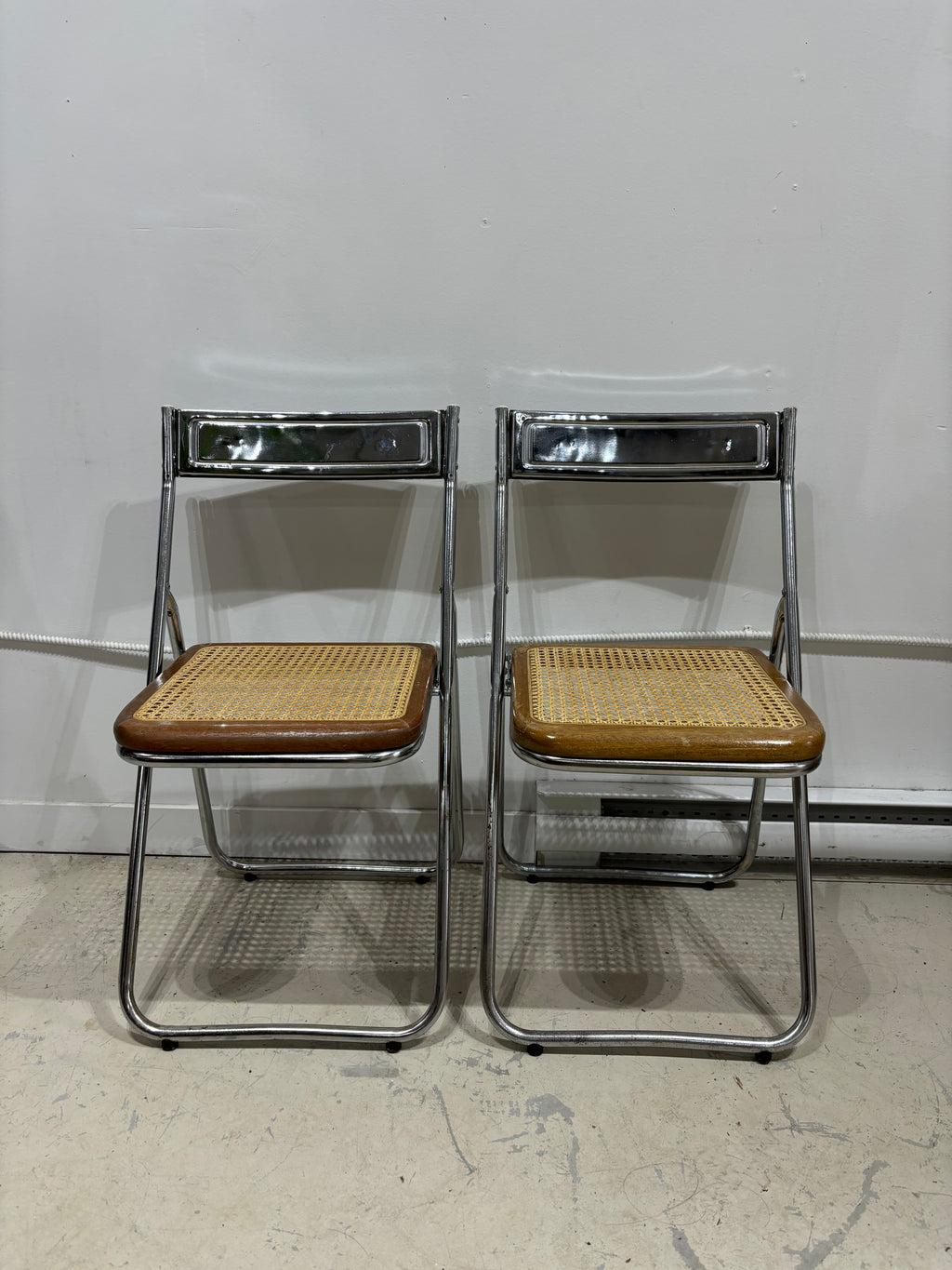 Paire de chaises pliantes en chrome avec assises en cannage