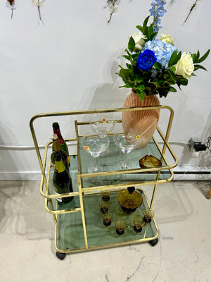 Golden brass bar cart with smokey black glasses