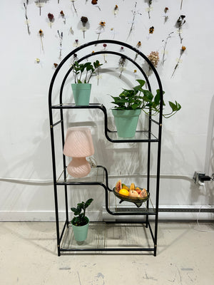 Black arched metal shelf with golden brass accents