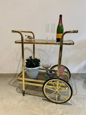 Golden brass bar cart with two handles