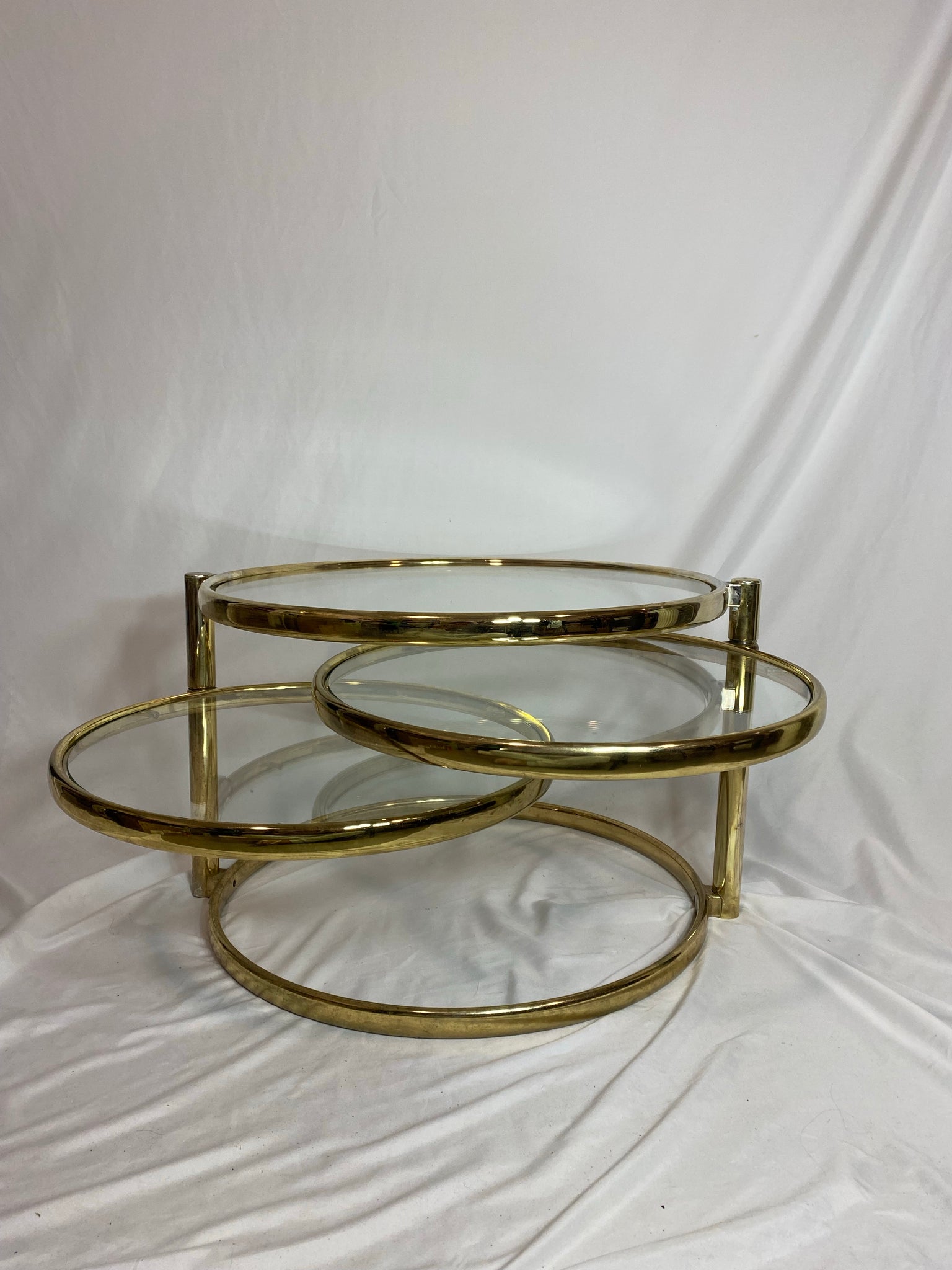 Golden brass & glass round swivel coffee table