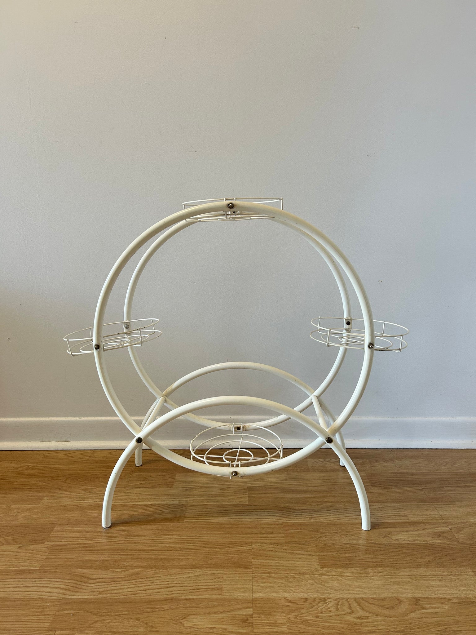 Round white tubular metal plant stand