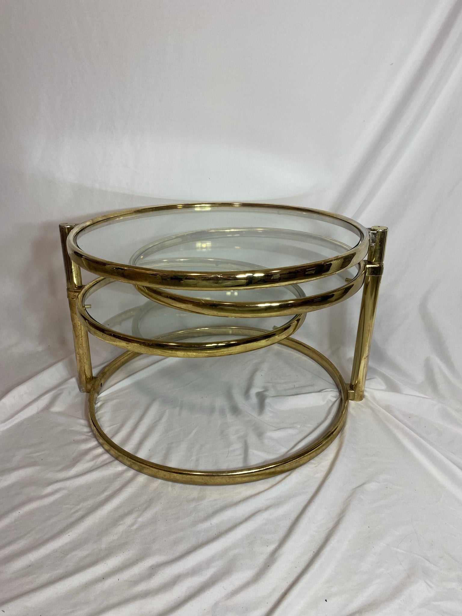 Golden brass & glass round swivel coffee table