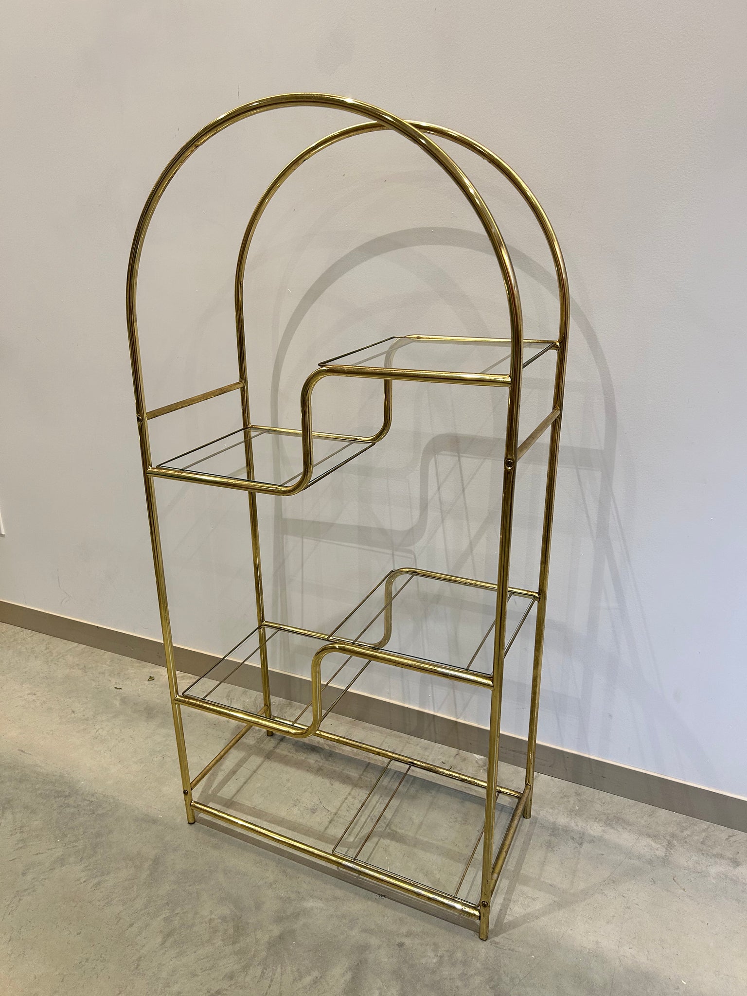 Golden brass arched metal shelf